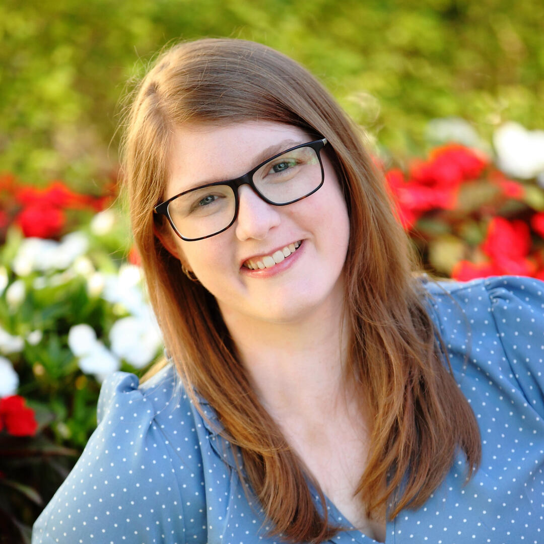 My headshot taken in front of a flower garden.